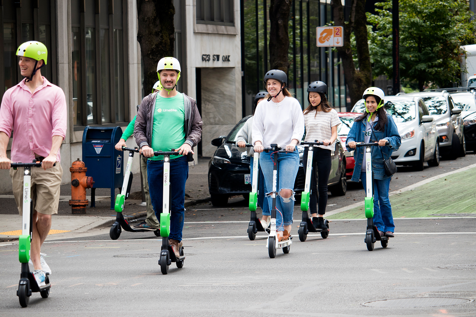 Group of friends ride Lime rental electric scooters through city in Australia