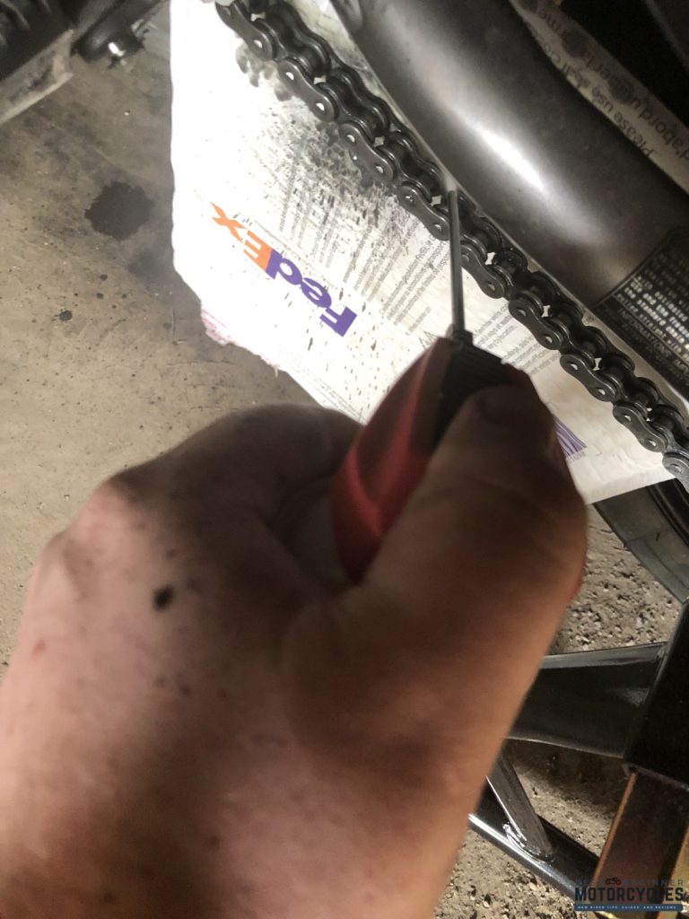 Spraying chain lube onto the chain (author's picture)