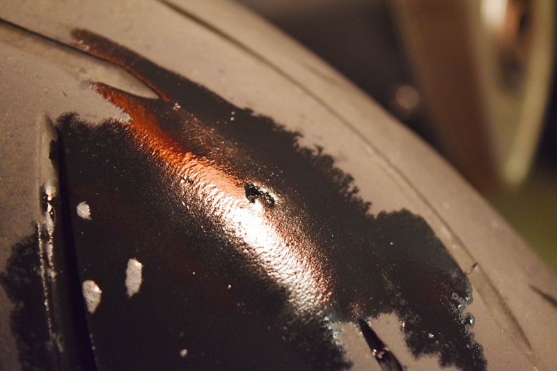 Water sprayed on tire puncture to check for leaking air bubbles