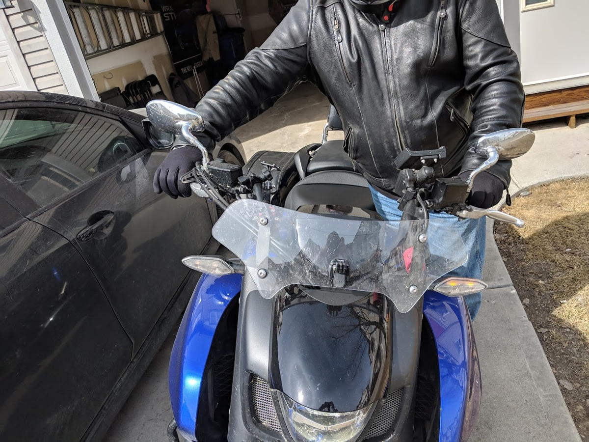 Motorcyclist with raised leg mounting motorcycle front view