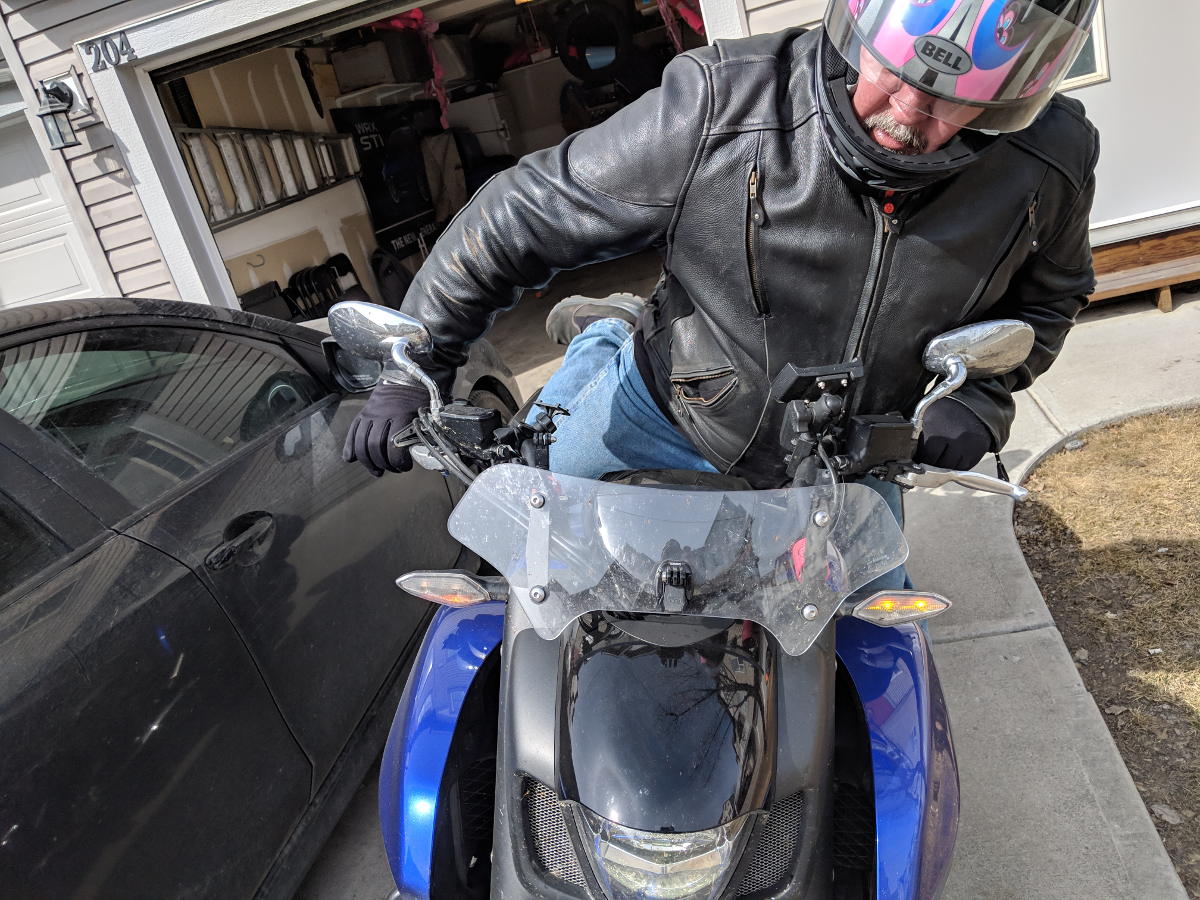 Motorcyclist with leg raised past the seat. mounting motorcycle