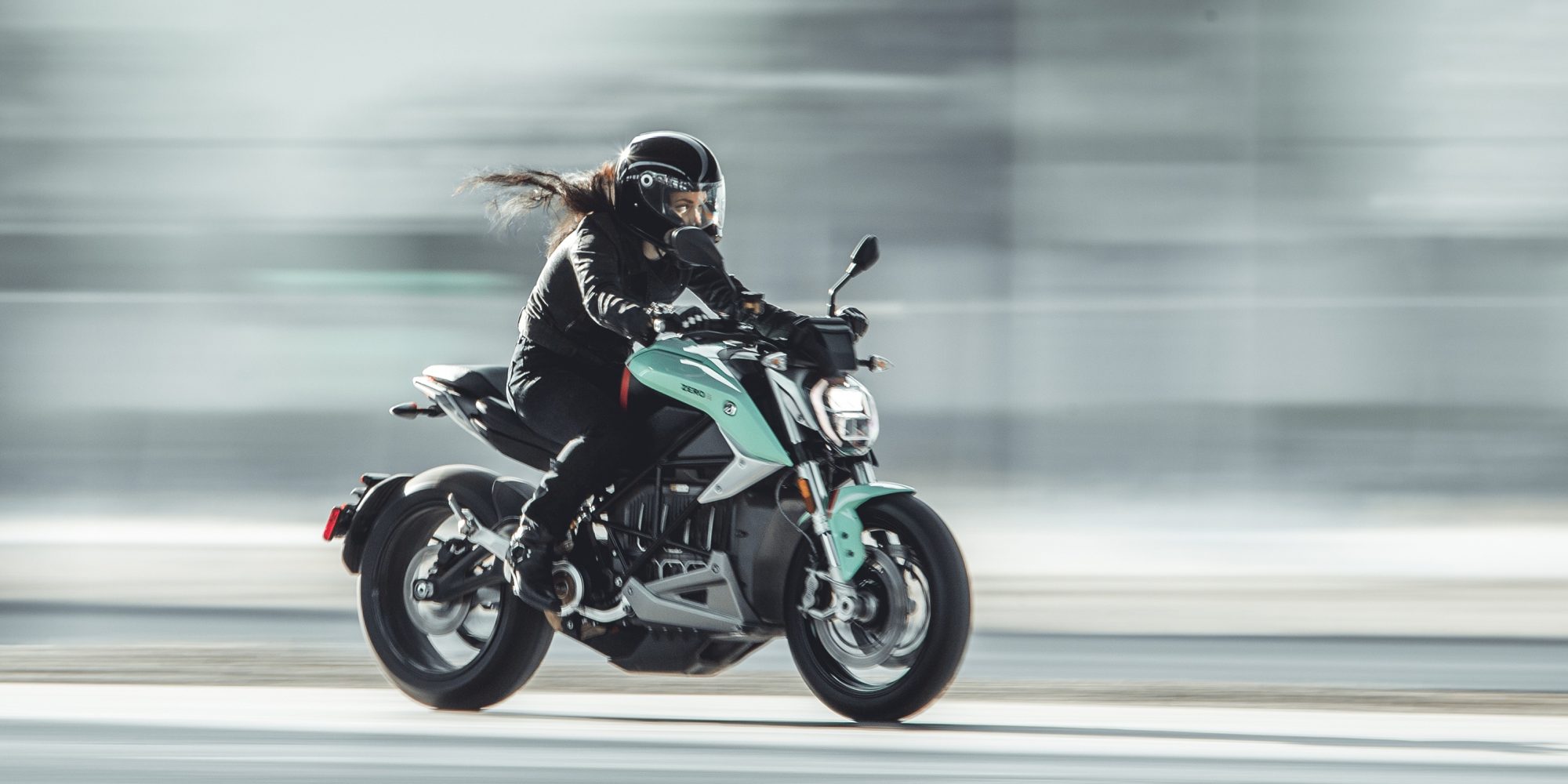 Woman on motorcycle travelling at speed