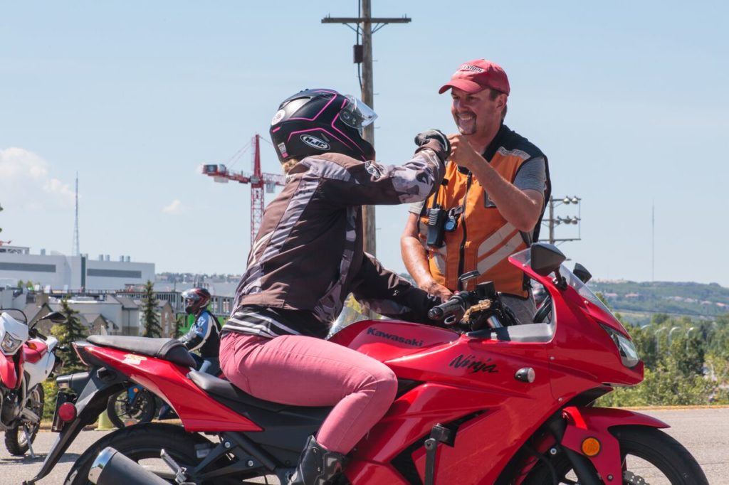 Female rider on a red Kawasaki Ninja