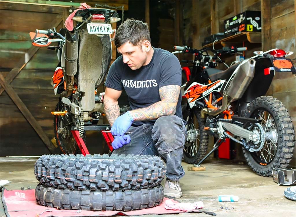 A man considers how to change the tyres on his offroad motorcycle