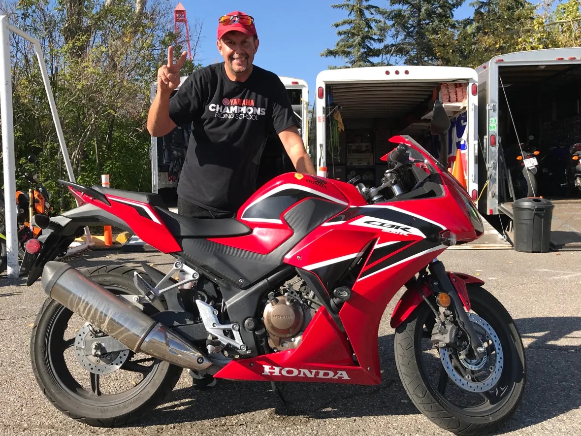 Trevor Dech standing behind a Honda CBR300R